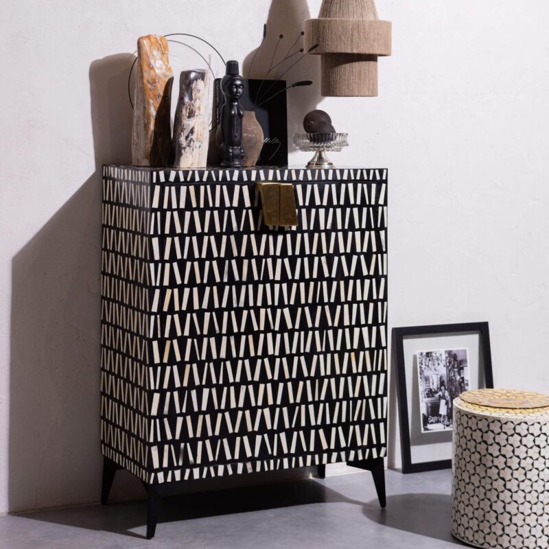 Cabinet de rangement noir/blanc avec cadre en bois de manguier, base en métal poudré et design en incrustation d’os.